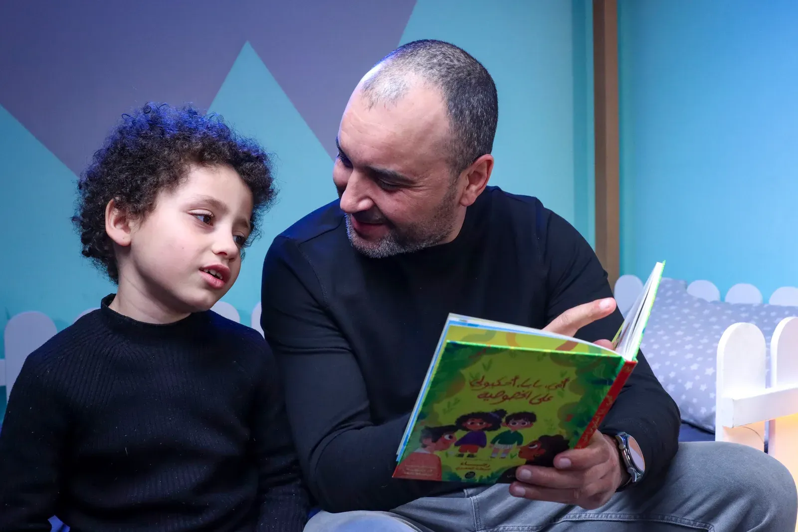 Un adulte et un enfant lisent le livre ensemble